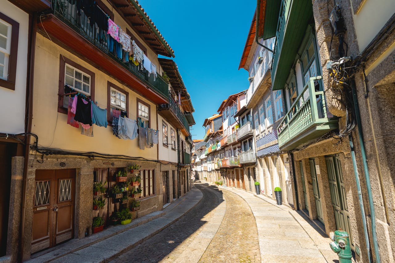 Picturesque view of narrow cobblestone street with colorful architecture in Guimarães, Portugal.